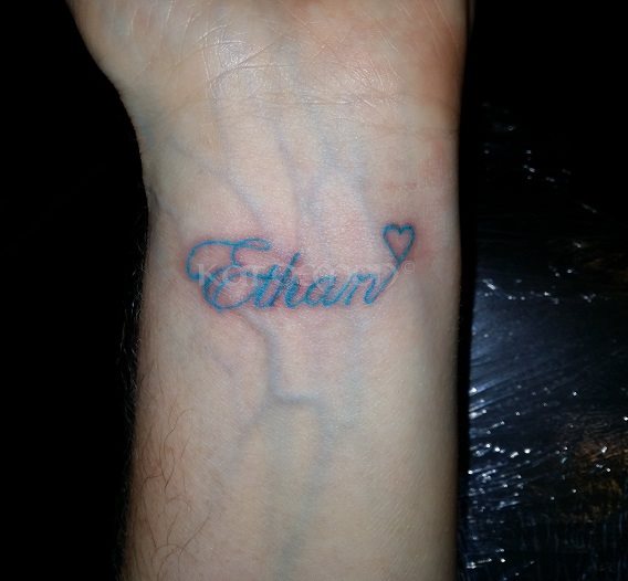 Ethan name on wrist tattoo